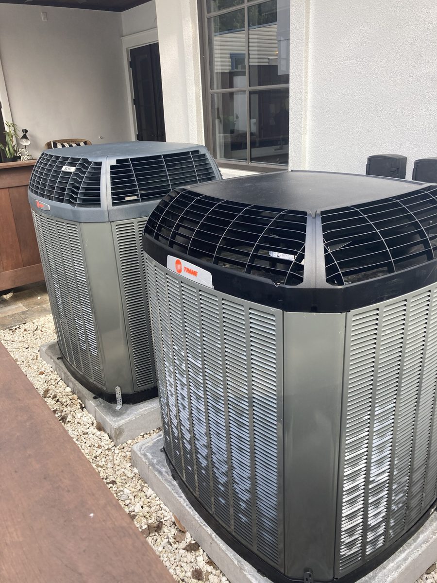 Two Trane outdoor condensing units installed cleanly on a paver pad at an upscale Panama City Beach home